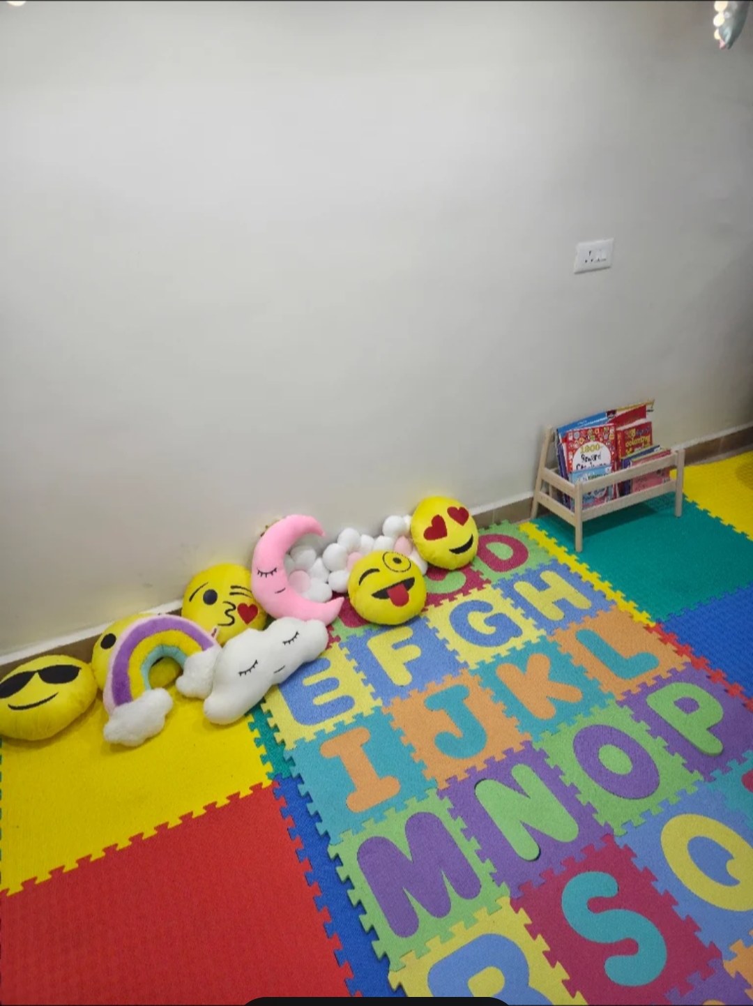 Alphabet floor mats, soft cushions and a small book rack