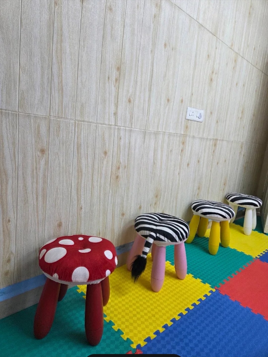 Mushroom and animal-patterned stools on colourful floor mats